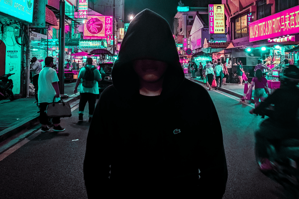 Hooded man standing in the middle of a street