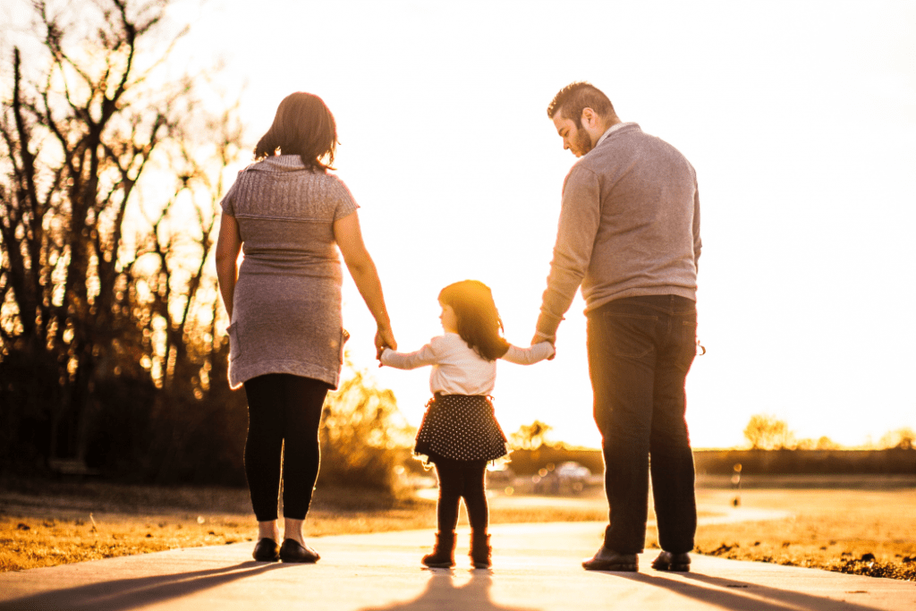 Mother and Father holding the hands of their daughter