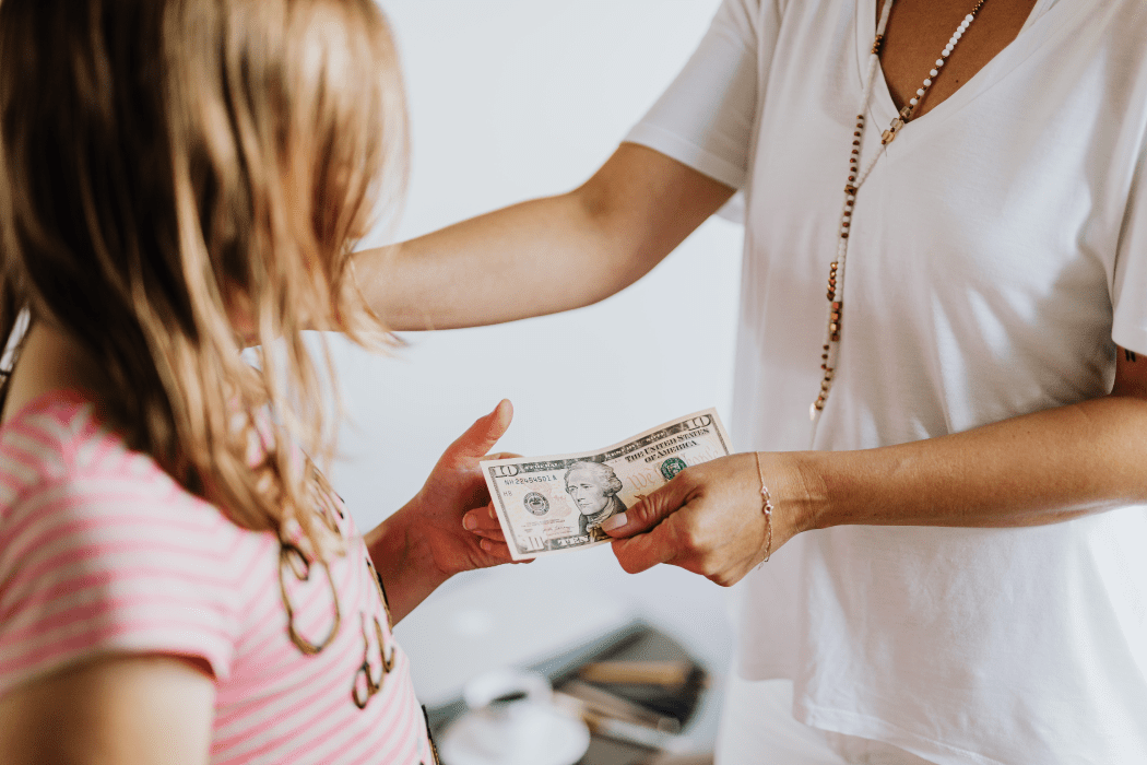 Mother giving daughter a $10 bill