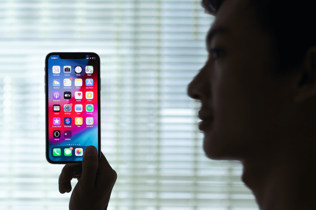 Man in shadow holding a phone