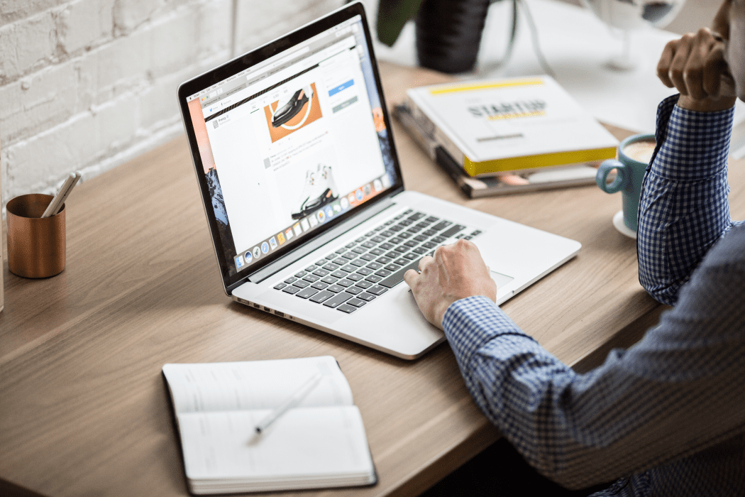 Man sitting at desk working on a silver laptop