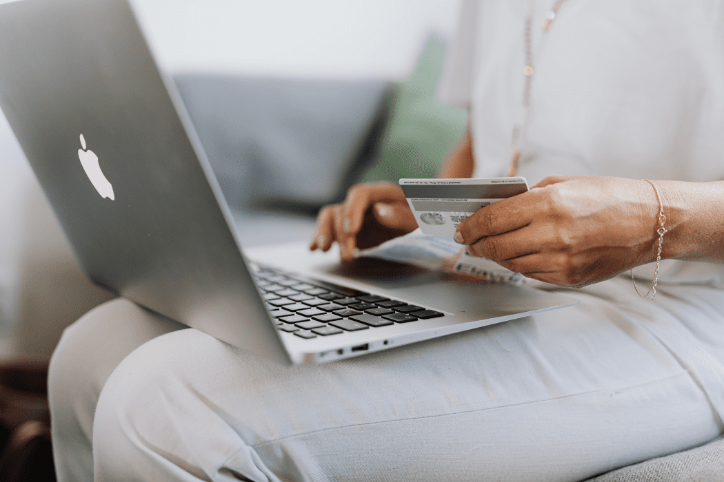 Person on a silver laptop paying for a product with a credit card