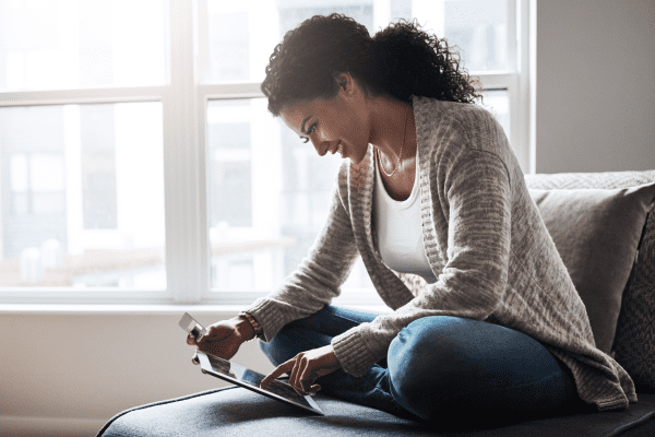 Woman sitting on couch using a tablet