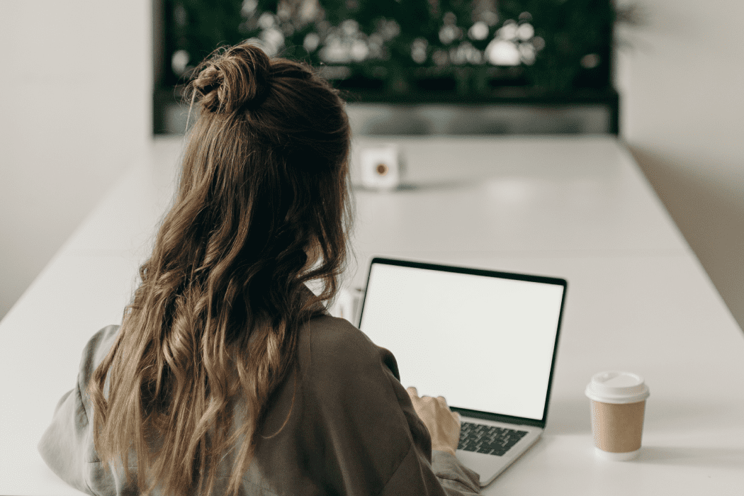 Woman at a table working remotely on her laptop