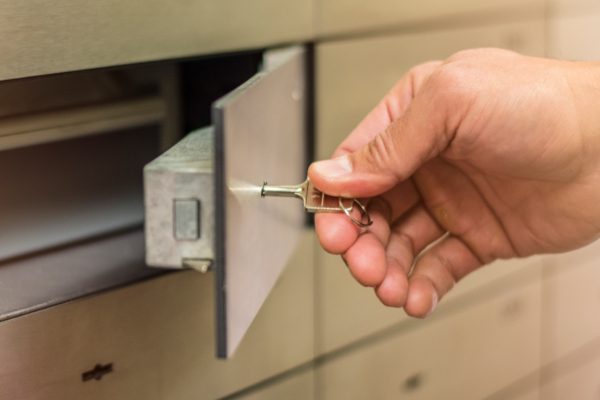 Hand using a key for safe deposit box
