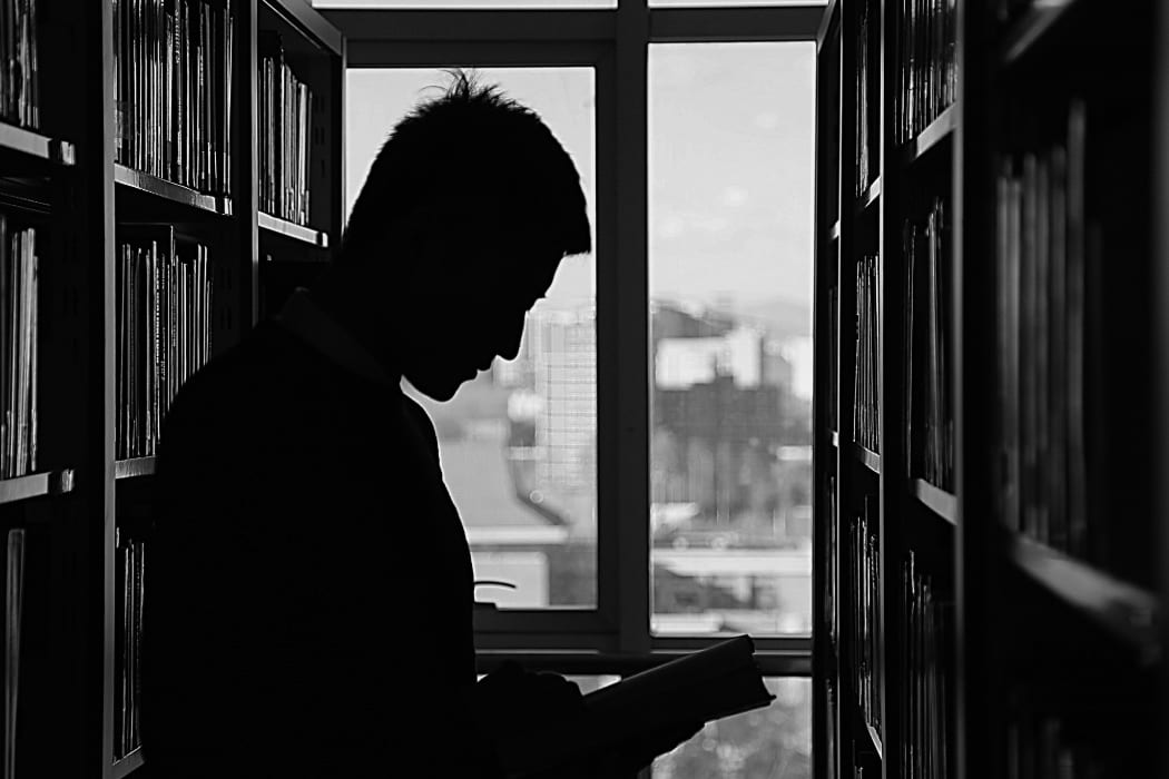 silhouette of man in a library