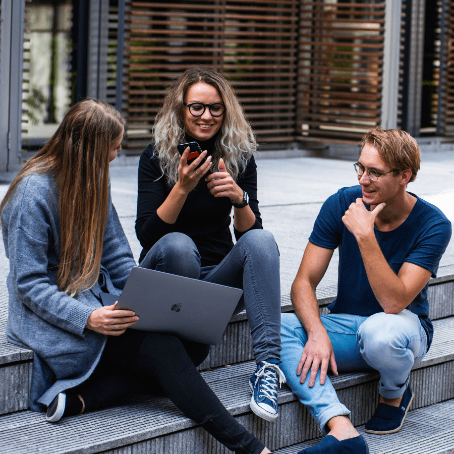 Three friends sitting on the school steps talking