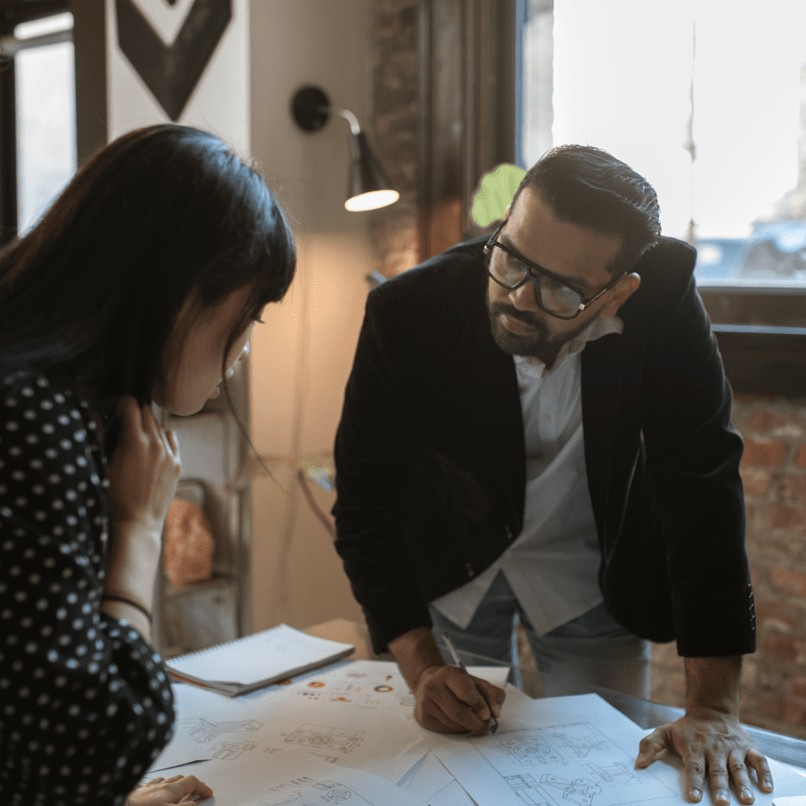 Man showing his coworker plans for a new project