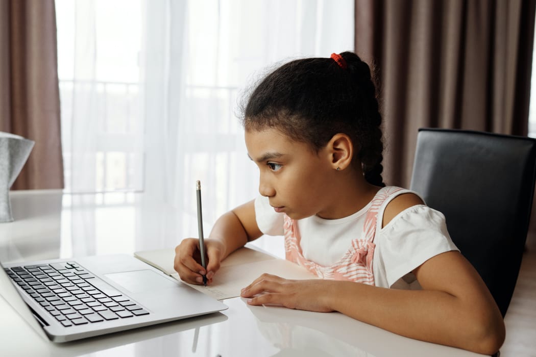 young girl with a pencil and paper doing homework