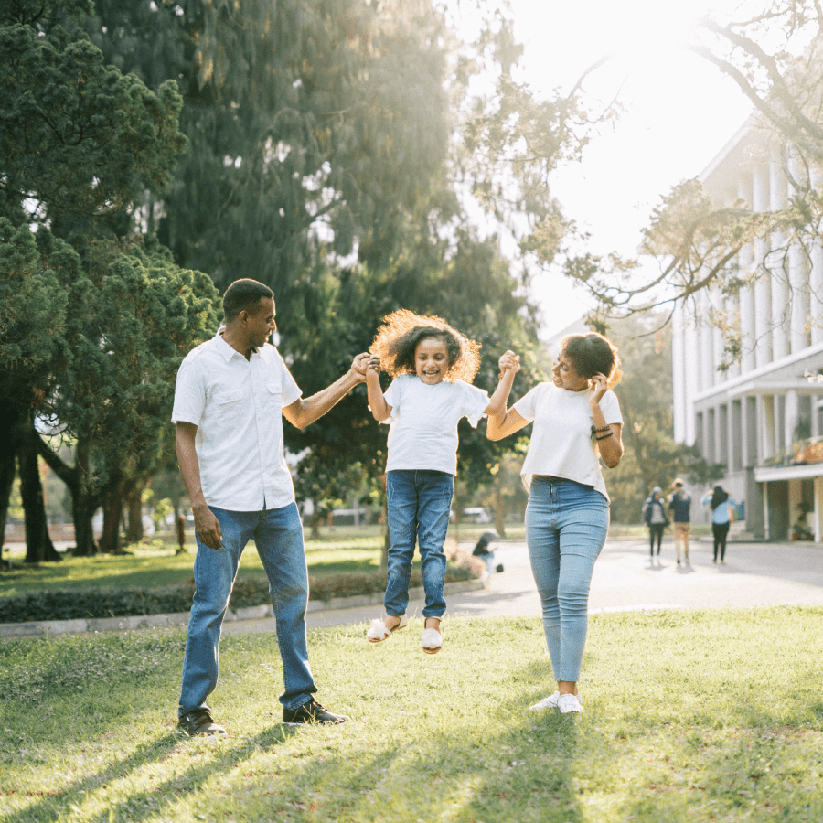 Mother and father holding their daughters hands