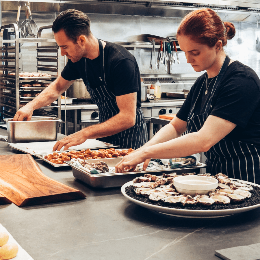 Two chefs creating a platter of food