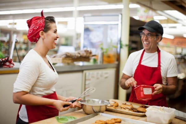 two restaurant employees working and smiling together