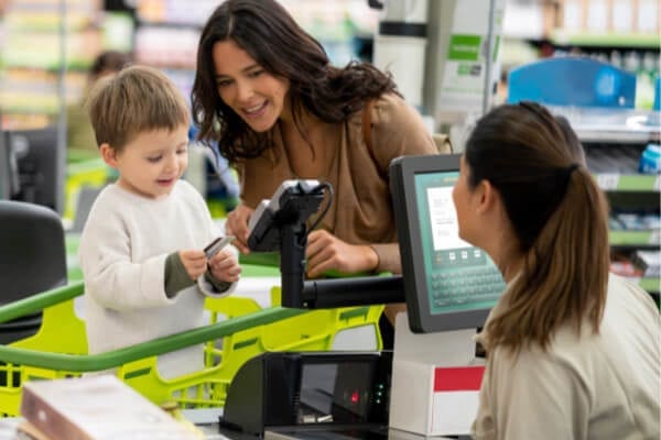 mother and son at a grocery store paying