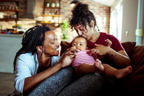 mother and father holding a baby and smiling