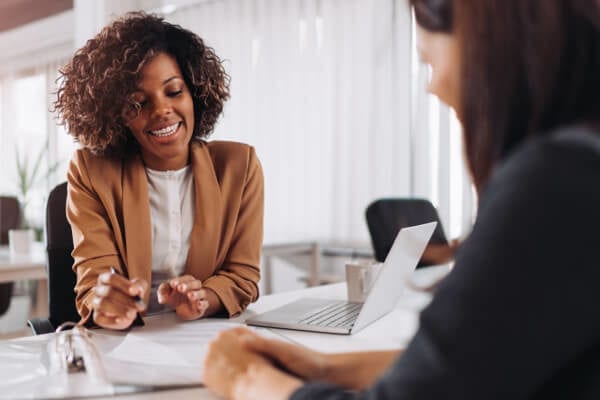 a woman sitting with a banker at a desk