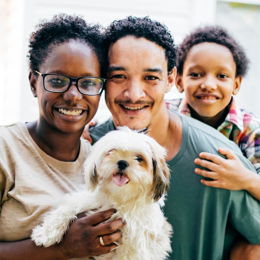 mother, father, child, and dog posing