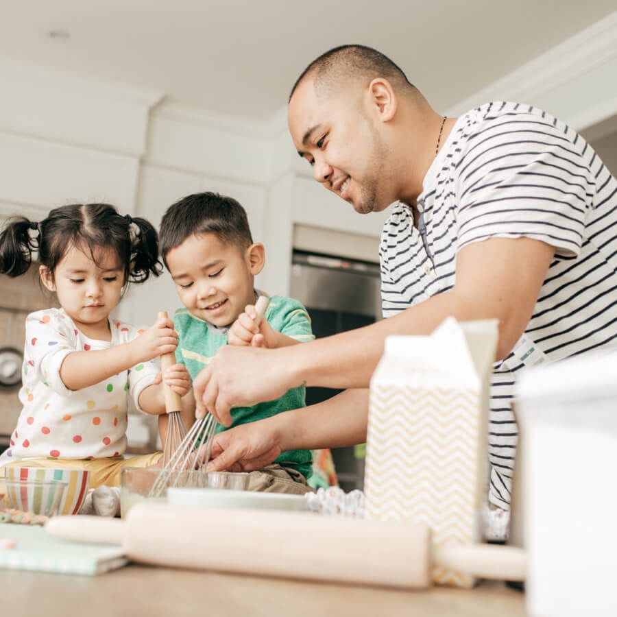 father and two children baking