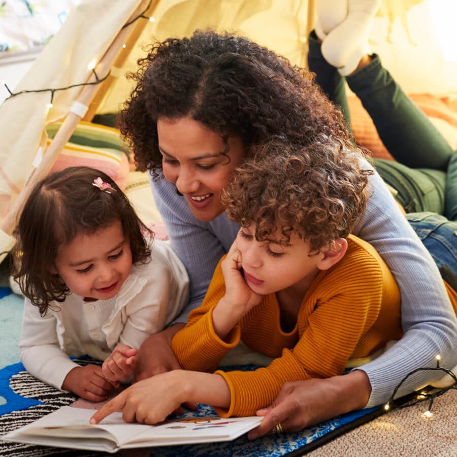 Mother with her two children reading a book