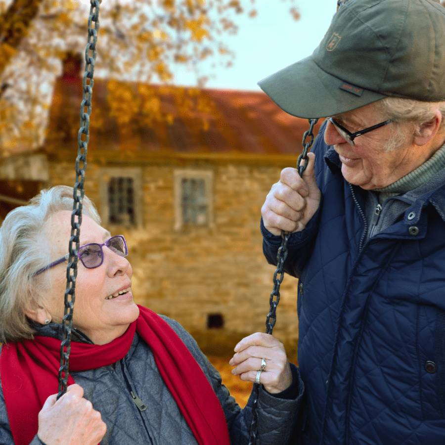 Senior man and woman sitting on a swing