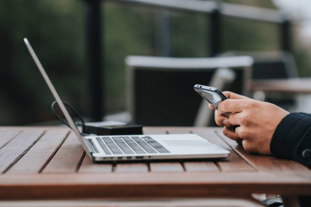 Image of someone using a laptop and mobile phone