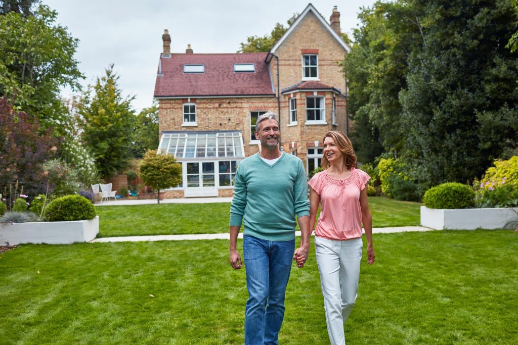 older couple walking in a yard holding hands