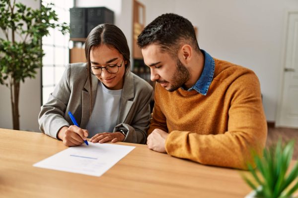 couple sitting at a table, signing documents