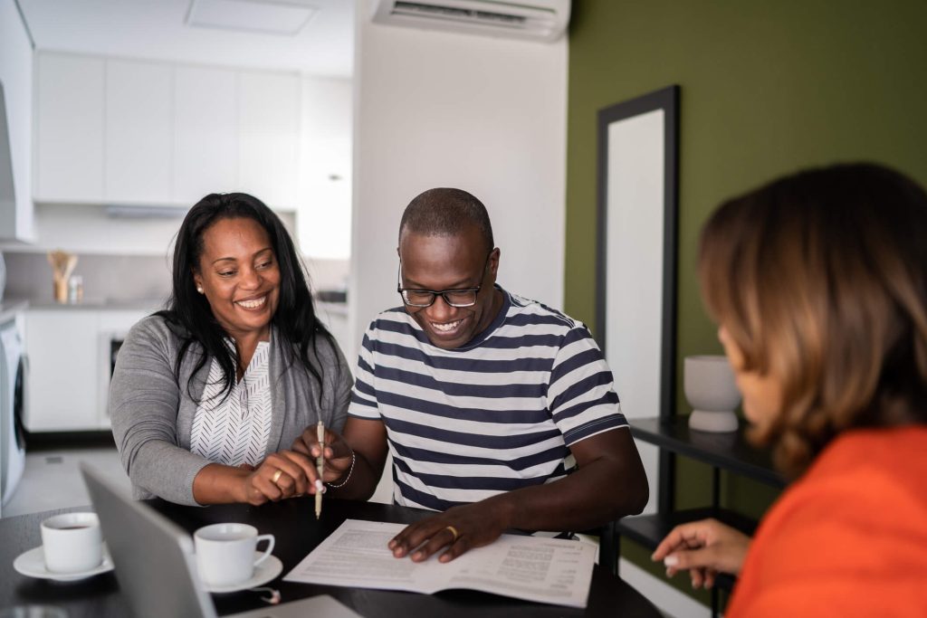 couple sitting at a table, signing documents with a lender