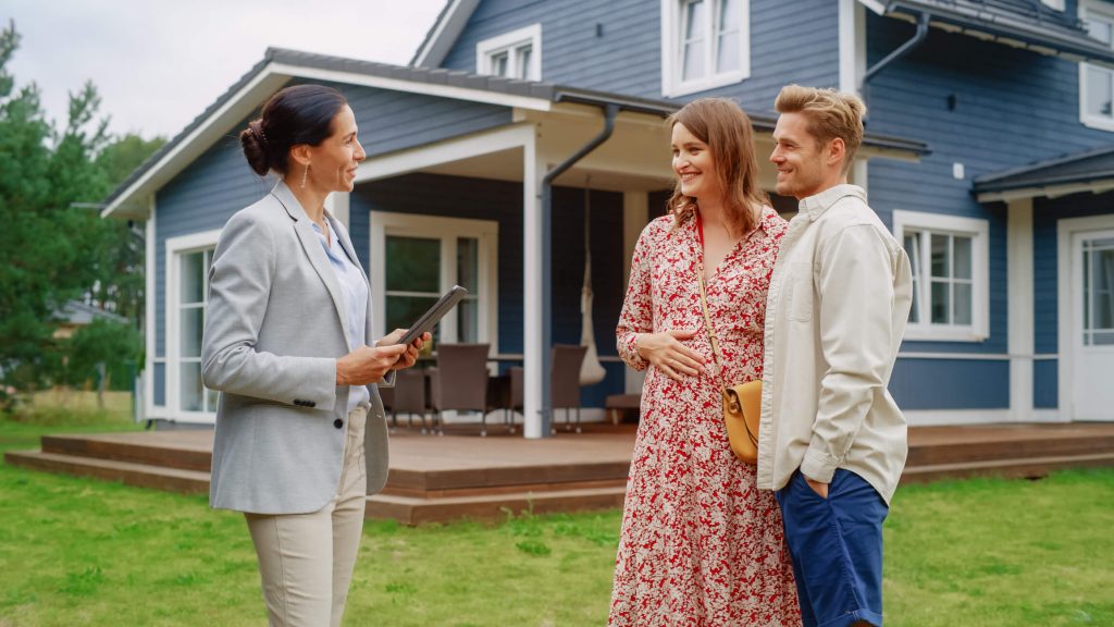 family talking to a professionally dressed woman in a yard