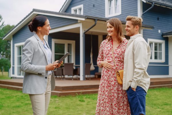 family talking to a professionally dressed woman in a yard