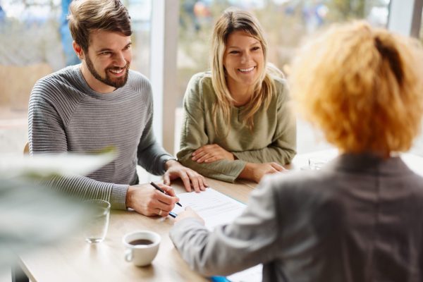 couple sitting at a table, signing documents with a lender