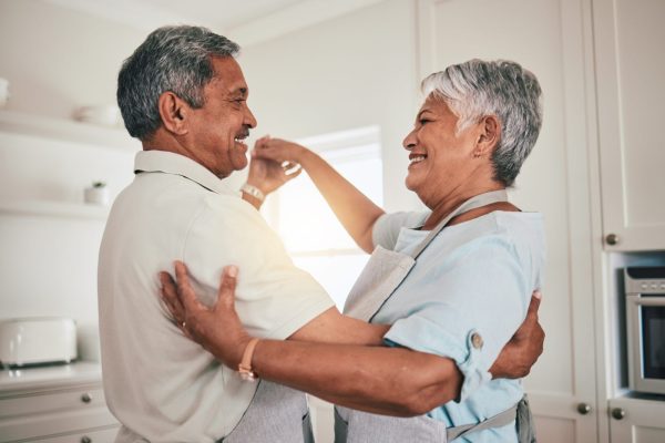 Couple dancing in the kitchen while smiling