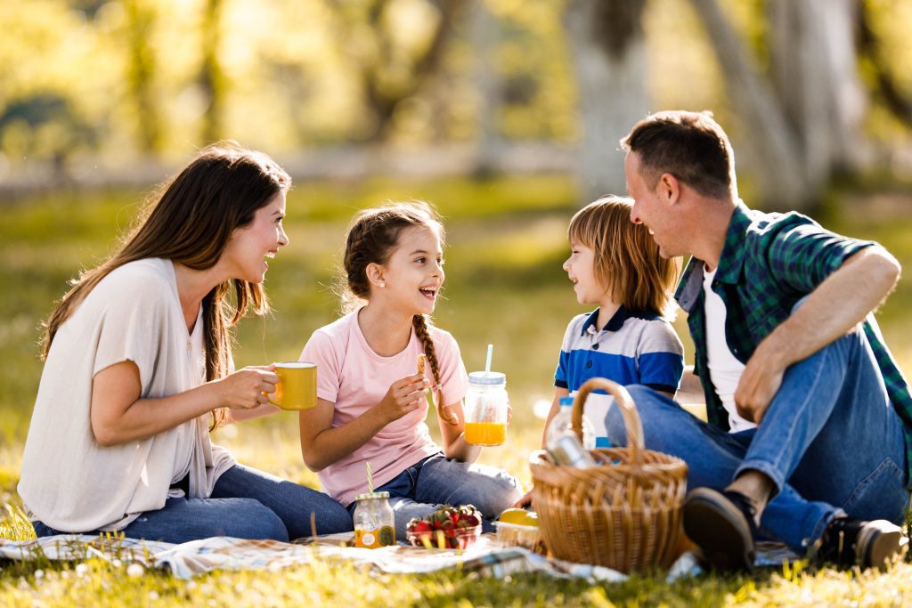 A family of four is having a picnic in a park.