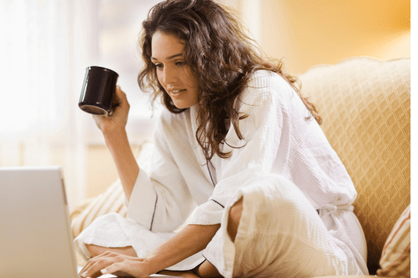 woman on couch with coffee and computer